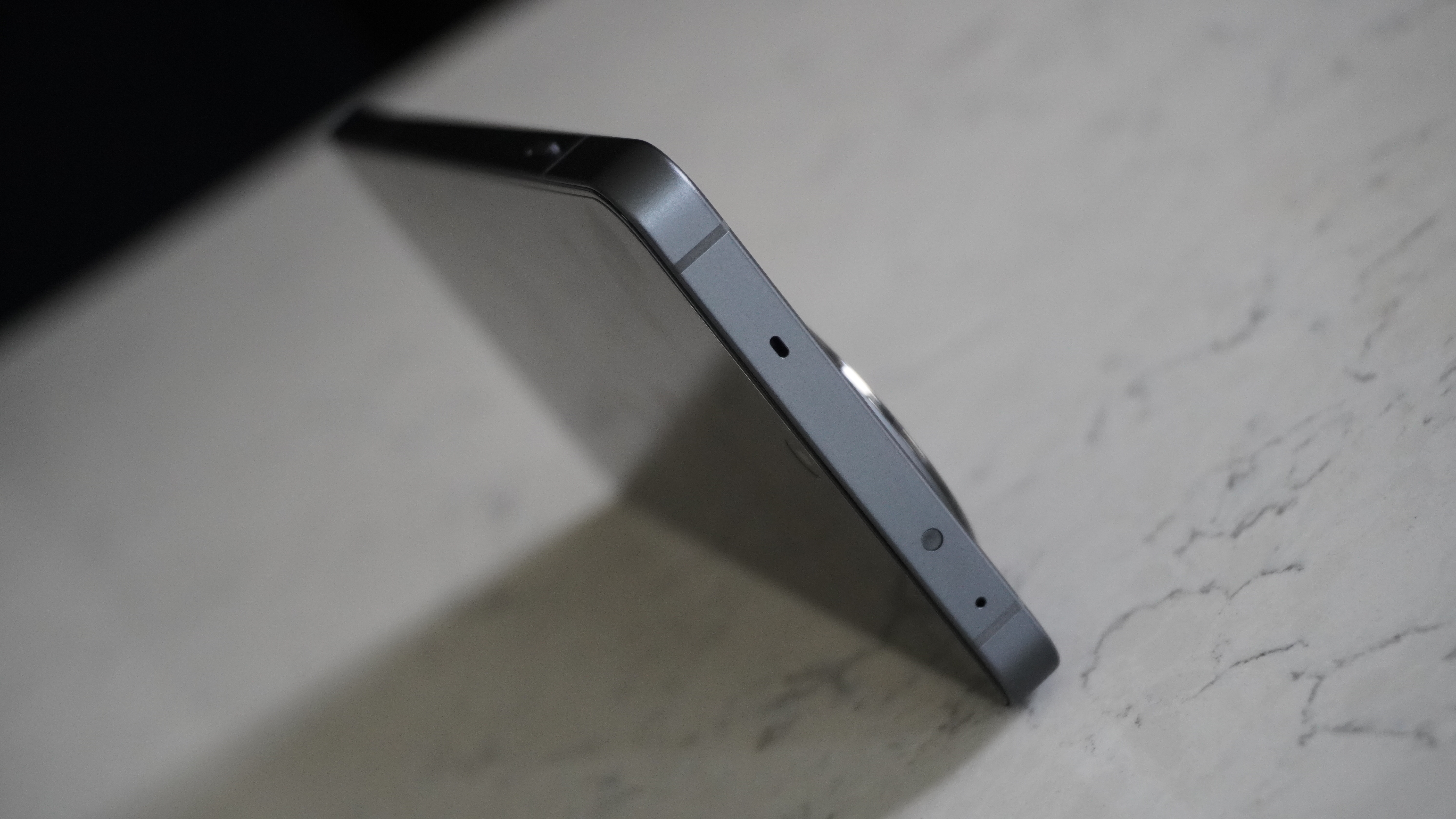 Side profile view of the OnePlus 13R showing the flat aluminum frame and buttons.