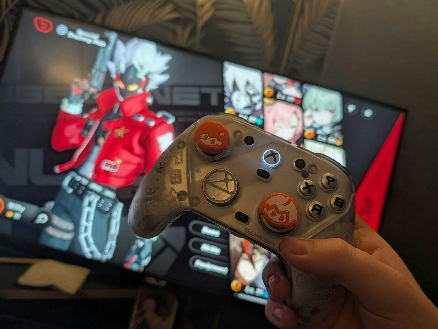 A gaming controller positioned in front of a high-end PC monitor setup.