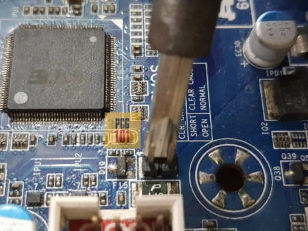 Instructional illustration showing a screwdriver touching the power switch pins on a PC motherboard.