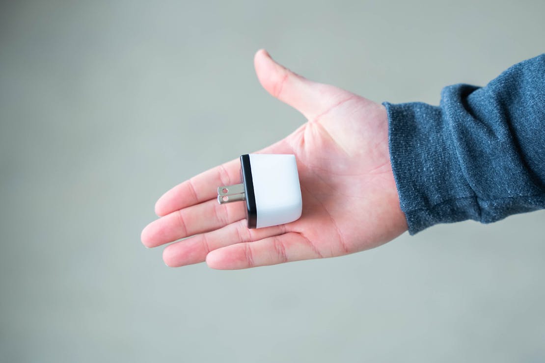 A small, thumb-sized USB-C device held between two fingers to show its compact scale.