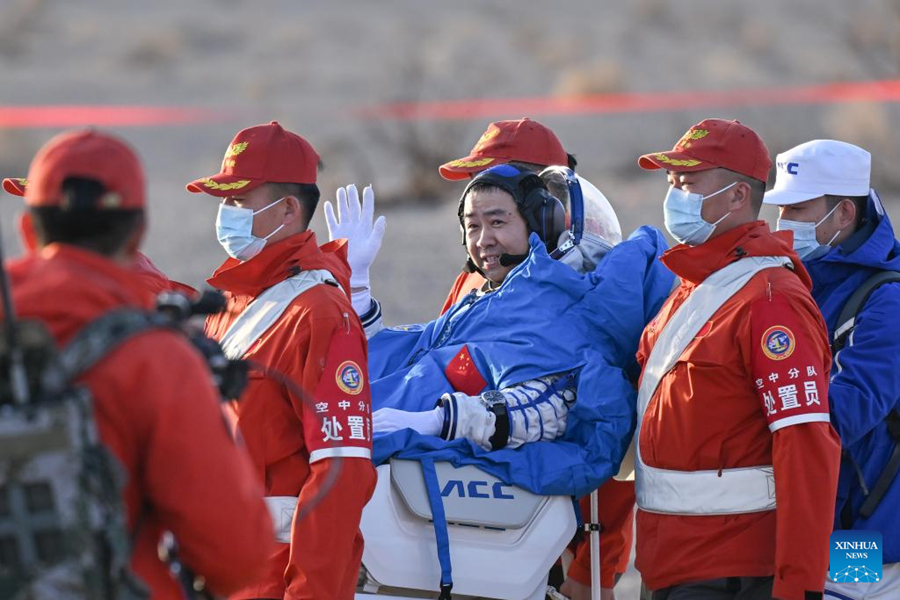 The three Shenzhou-20 astronauts sitting in chairs at the Dongfeng landing site after their return to Earth.