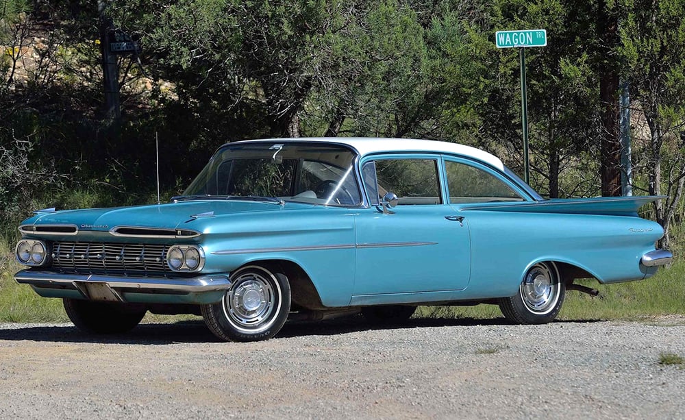 Side profile of a 1959 Chevrolet Biscayne, showing the 'batwing' tail fin design language.