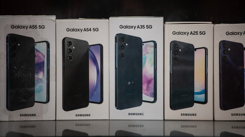 Retail display of multiple Samsung Galaxy smartphone boxes on a store shelf.