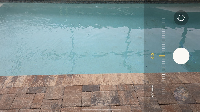 Camera viewfinder UI with the exposure slider active and adjusted for brightness.