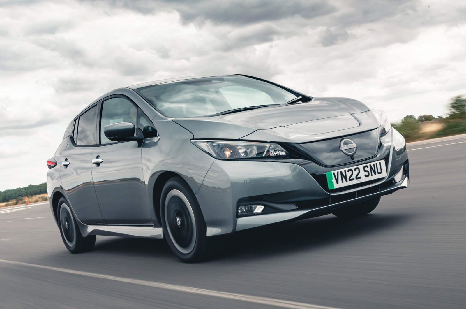 Front view of a white Nissan Leaf parked on a street.