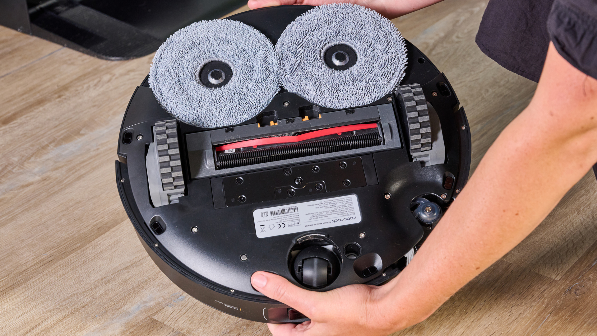 The bottom of the Roborock Saros Z70 showing the main brushes, side brush, and dual mop pads.