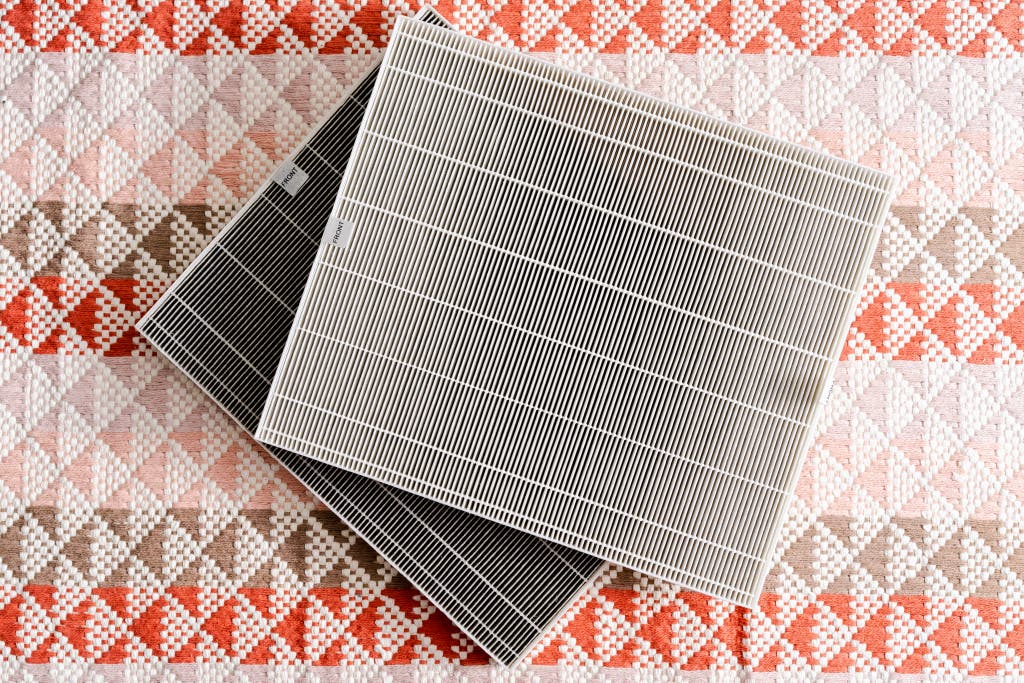 A side-by-side comparison of a bright white new filter and a grey, dust-clogged used filter.