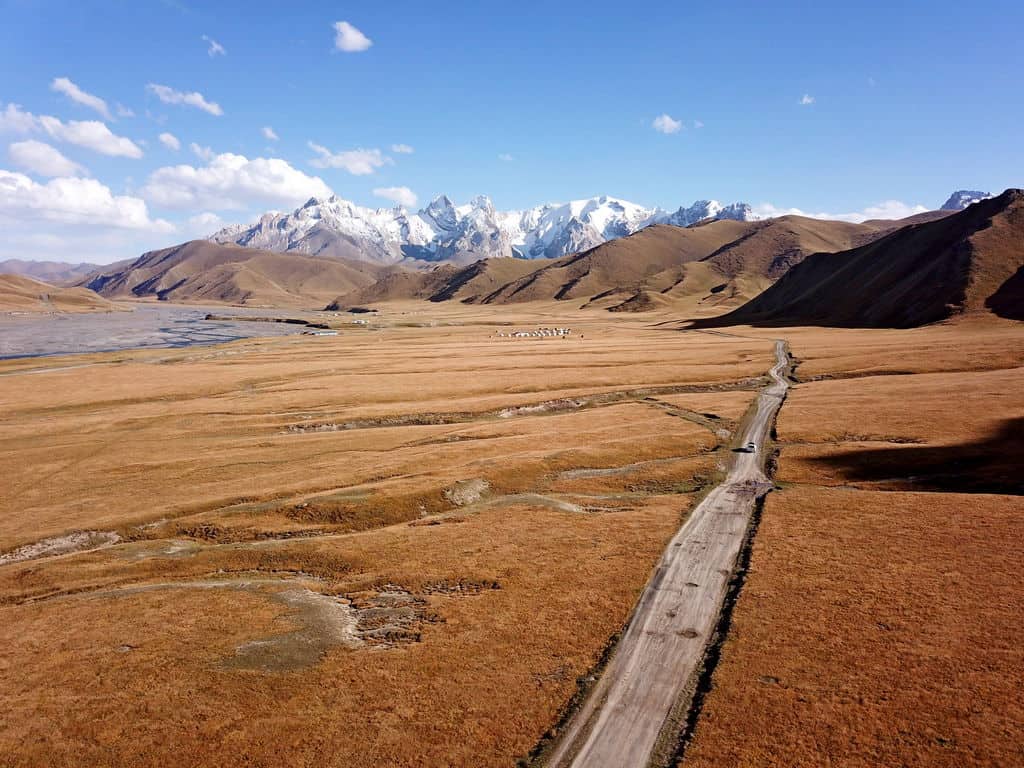 A high-angle aerial shot of the winding Kok Kiya Valley with dramatic mountain shadows.