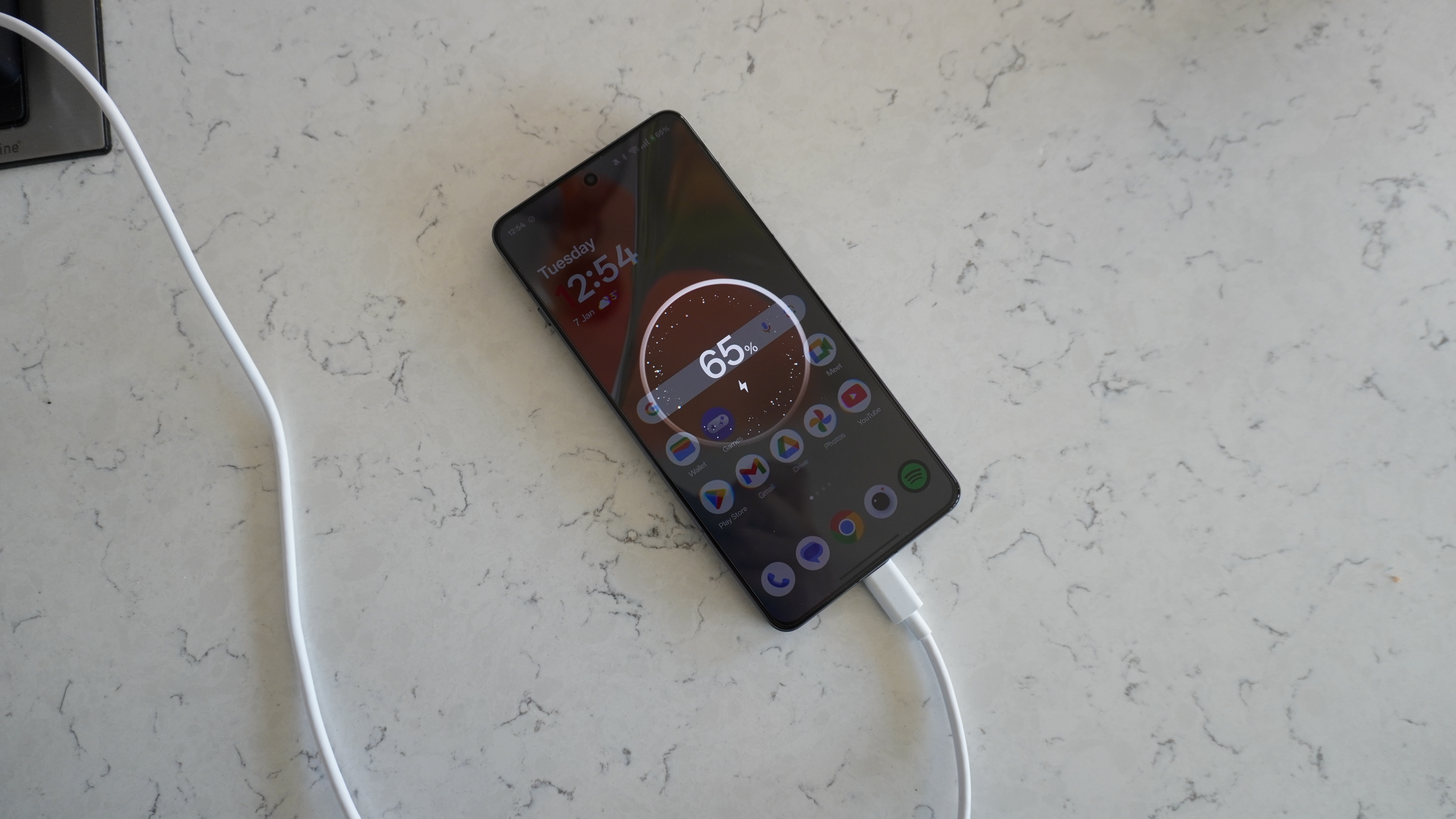 The OnePlus 13R on a surface, highlighting its long-lasting power capabilities.