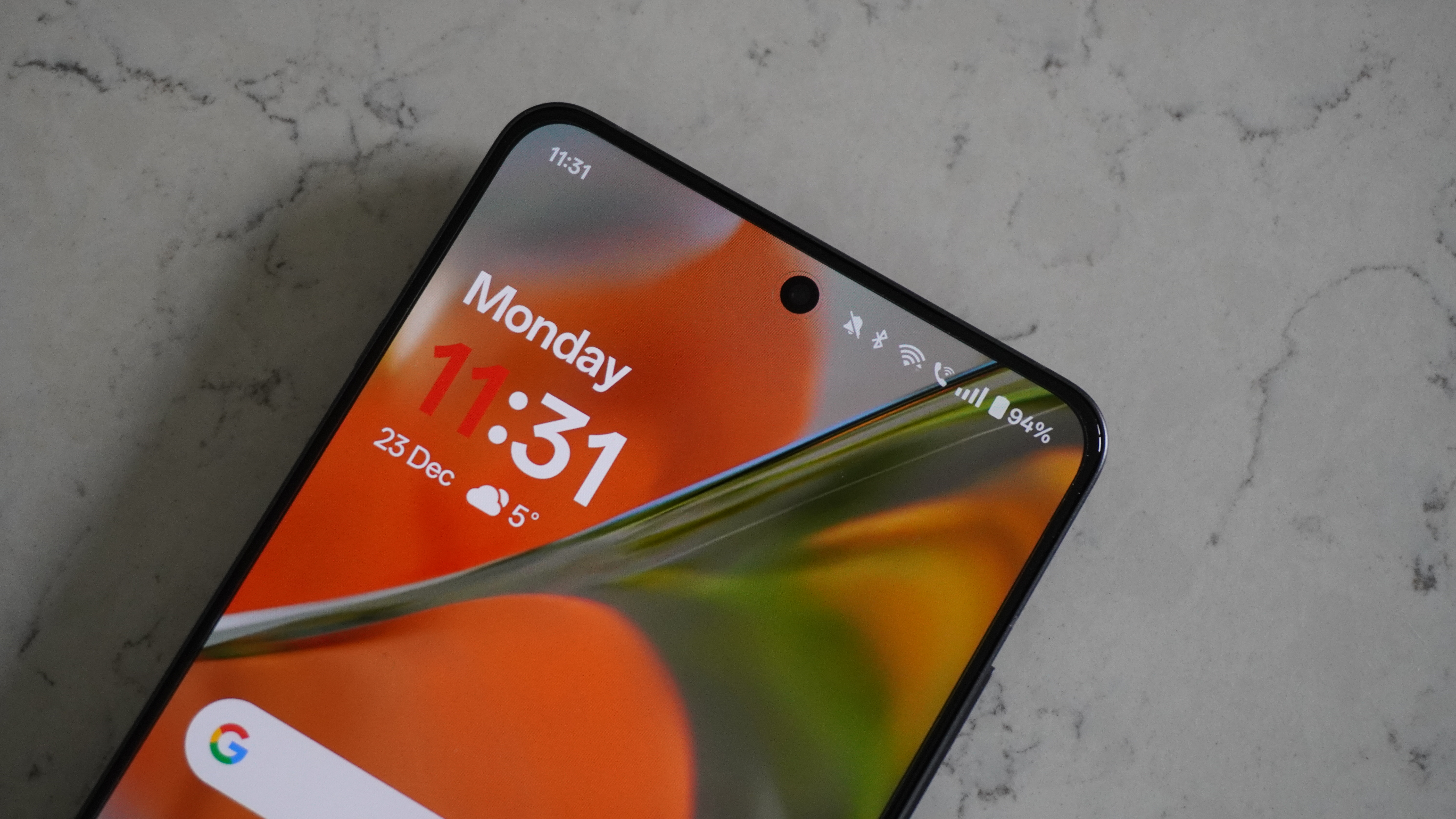 The OnePlus 13R display turned on, showing vibrant colors and thin bezels.