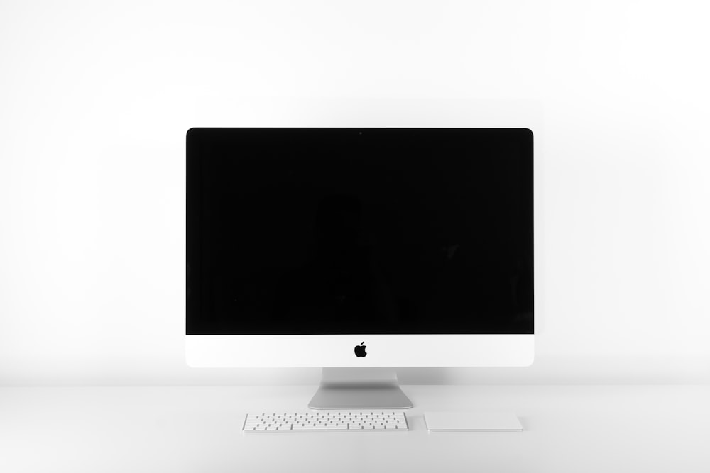 A desktop setup featuring a non-Apple wireless mouse and keyboard alongside a MacBook.