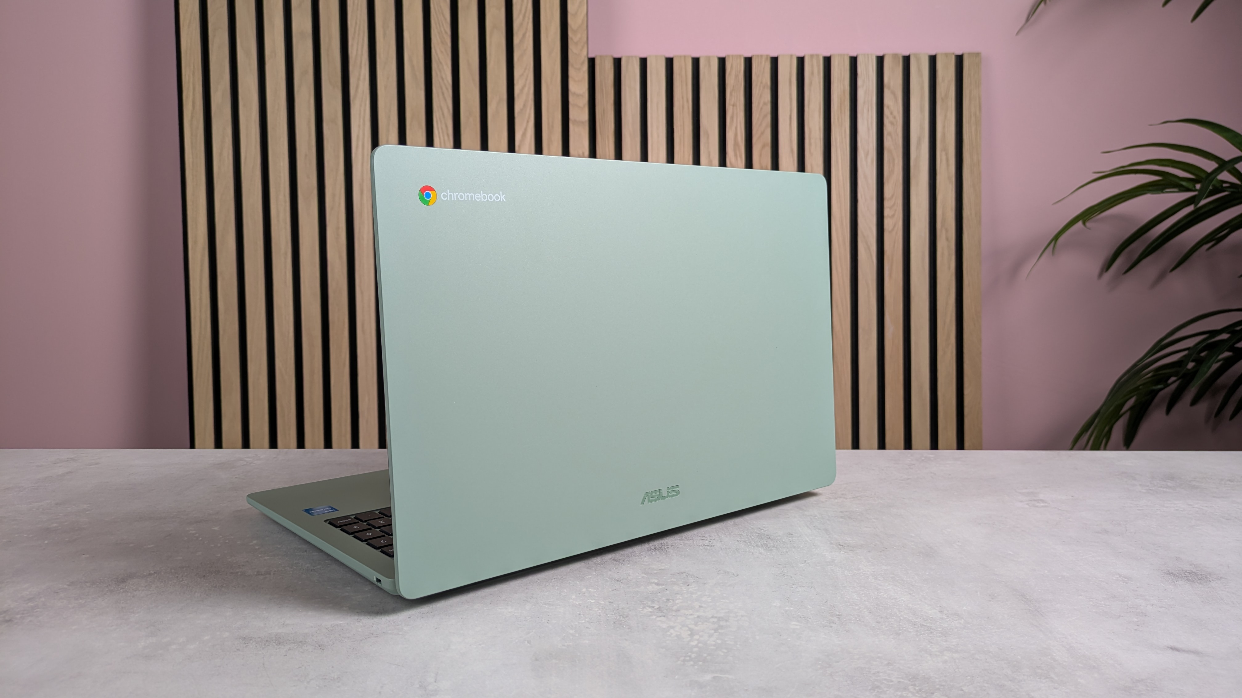 An ASUS Chromebook CX15 sitting on a wooden desk environment