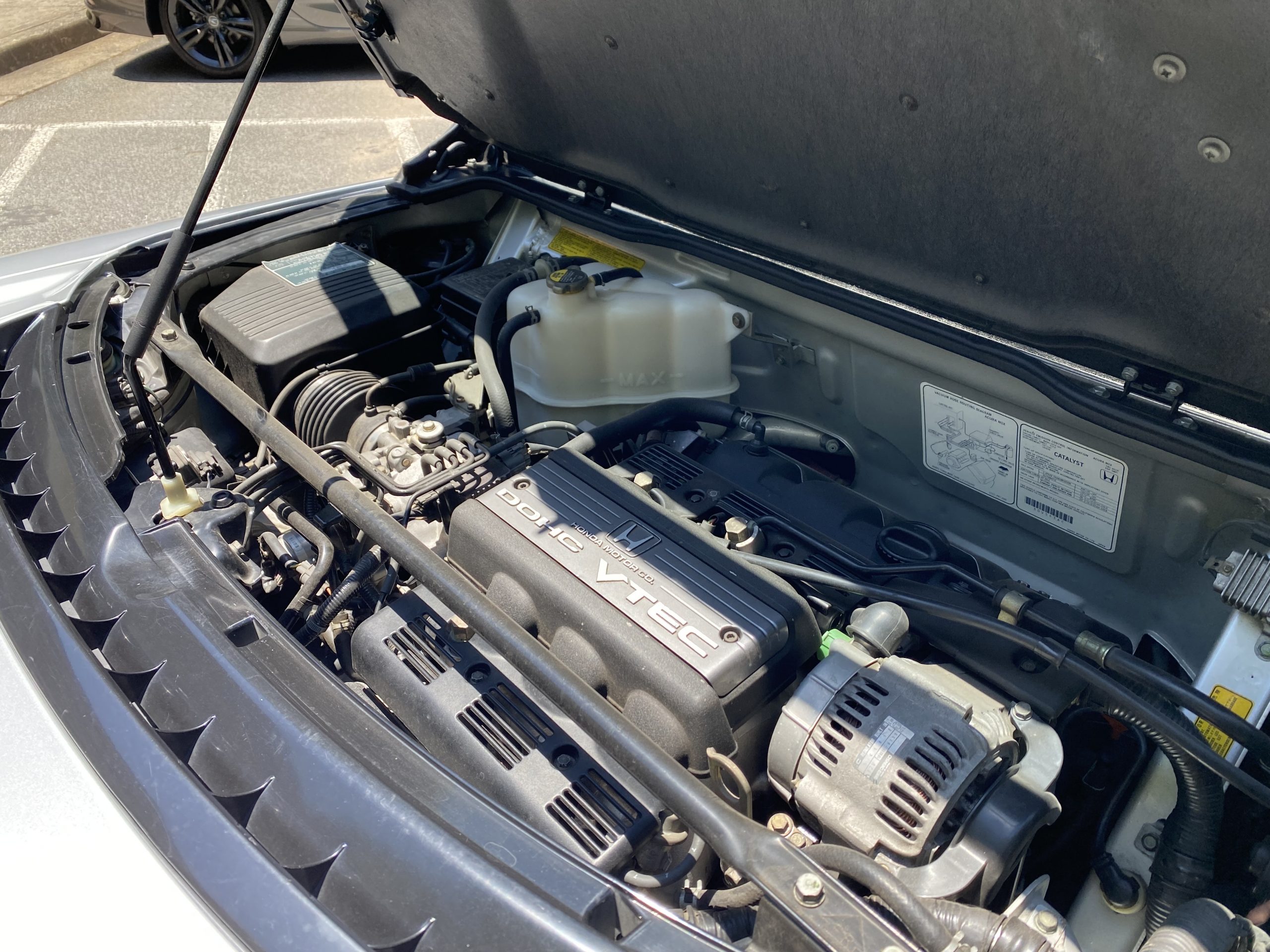 Close-up shot of the Acura NSX's leather-wrapped steering wheel and analog gauges.