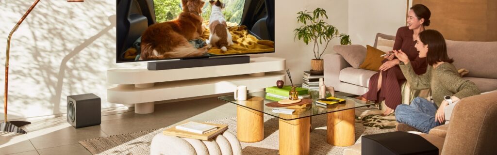 Samsung HW-Q990F soundbar system with wireless rear speakers and a subwoofer in a luxury home setting.