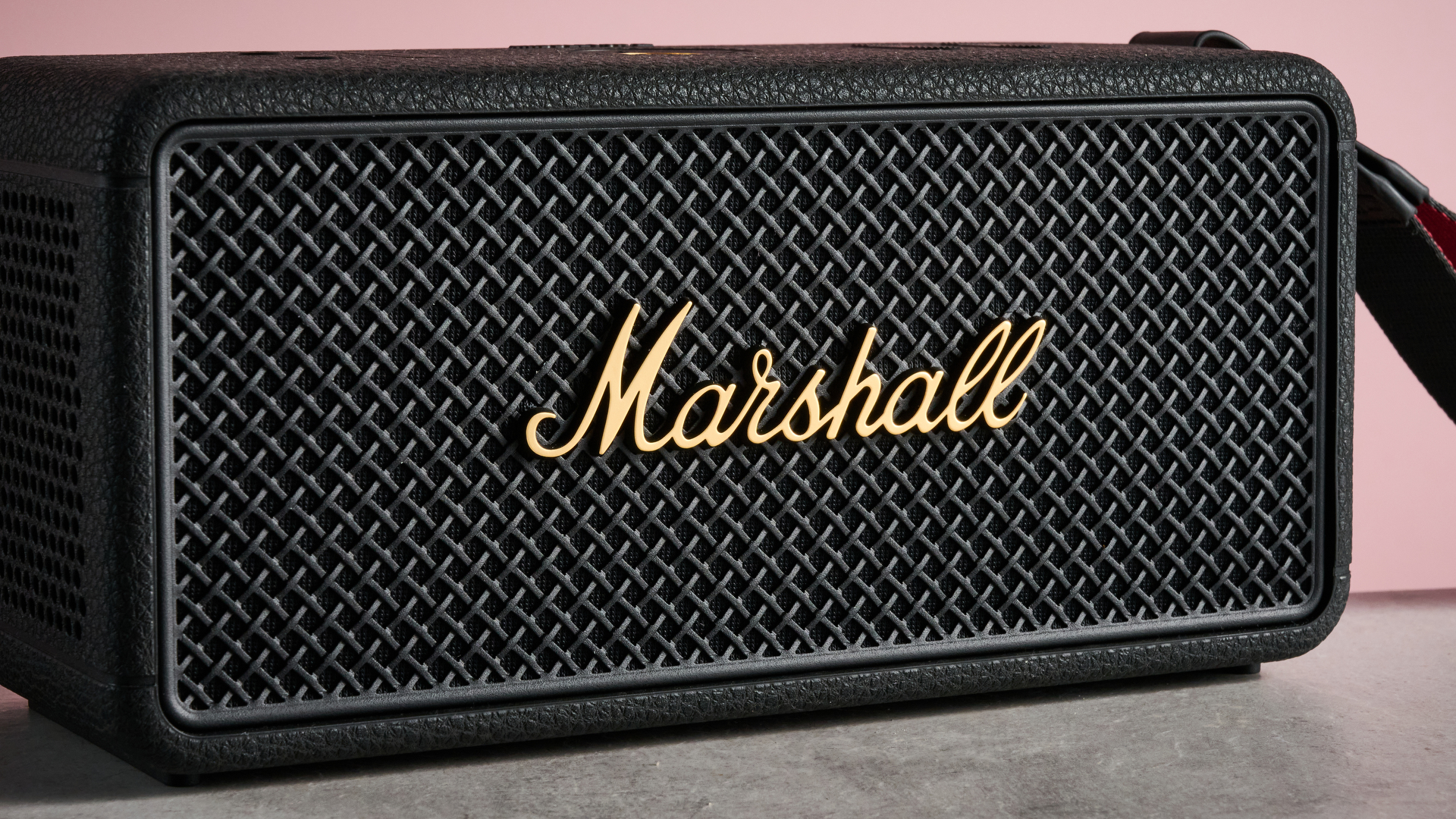 Macro shot of the white Marshall script logo on the black metal grille of the Middleton 2.