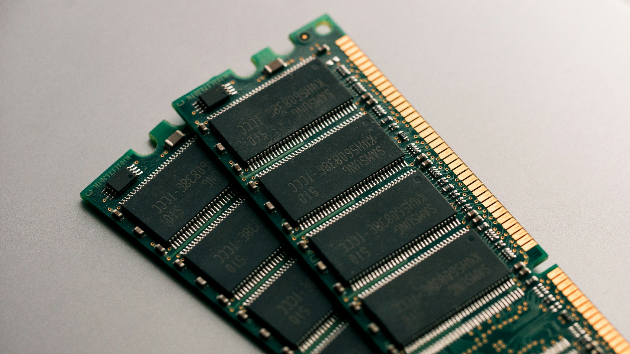 Two sticks of laptop RAM memory modules placed on a reflective surface.