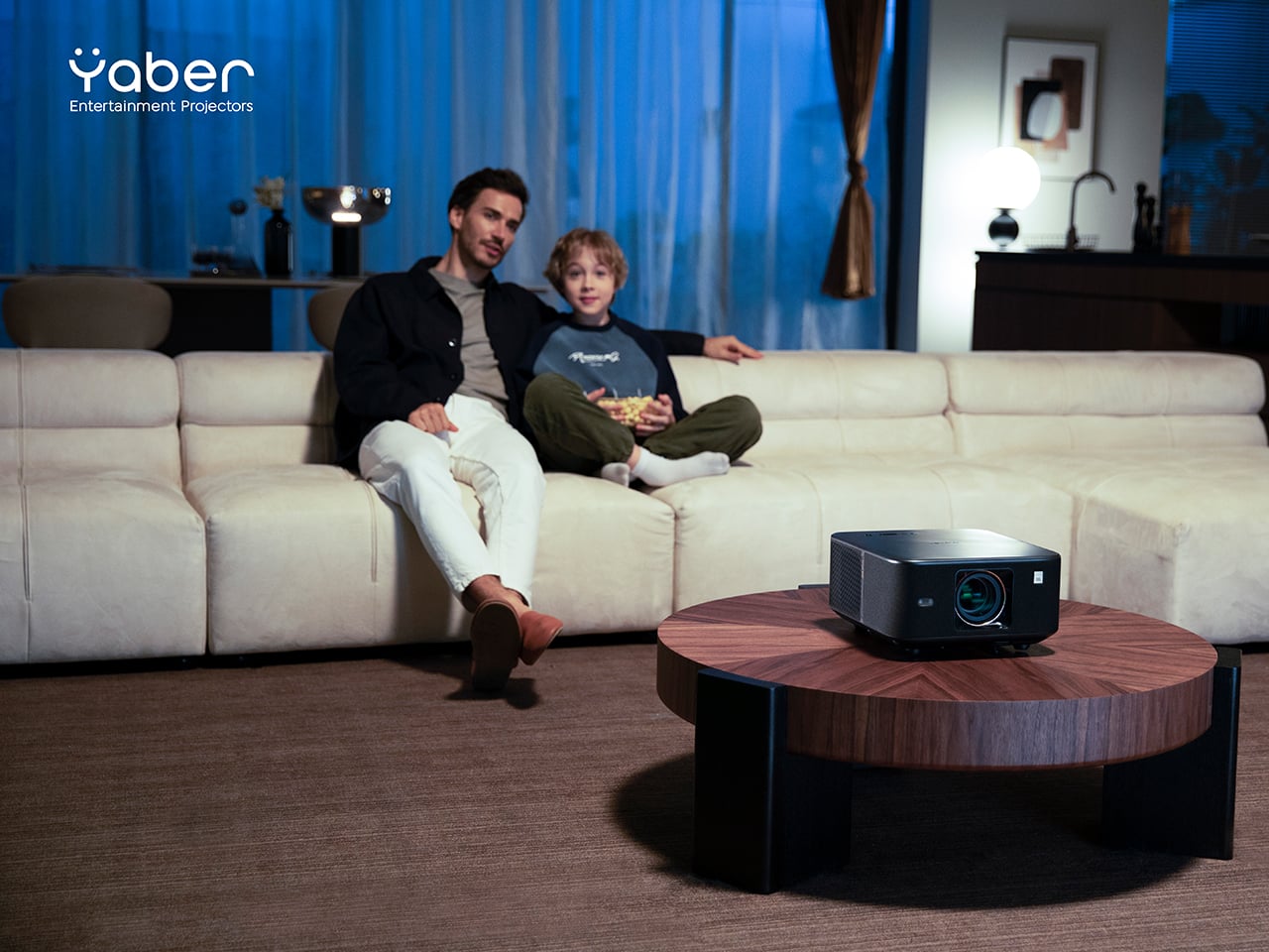 A Yaber K3 projector in a cozy, dimly lit room projecting a movie onto a large wall.