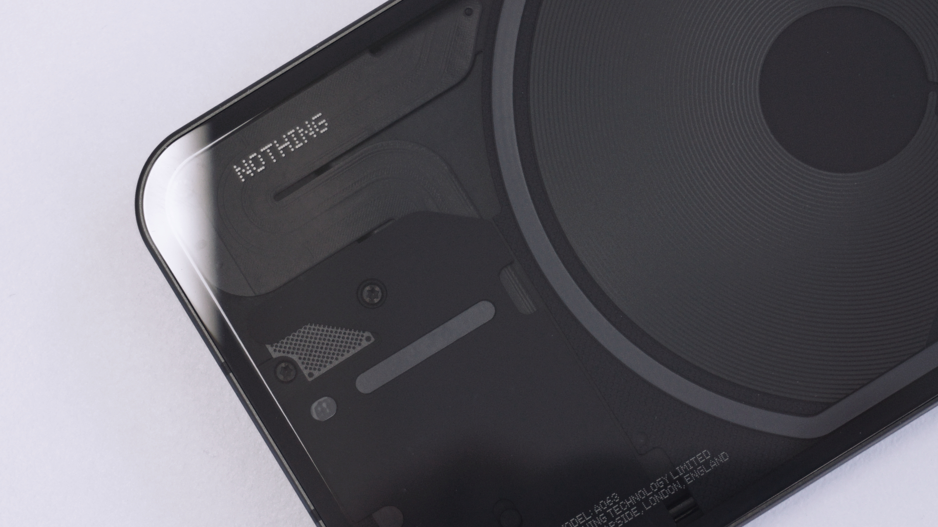 Close-up of the Nothing Phone 1's transparent rear panel showing the internal coils and brand logo.