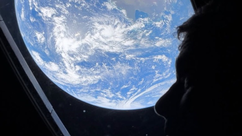 Artemis 2 mission crew member with Earth in the background.