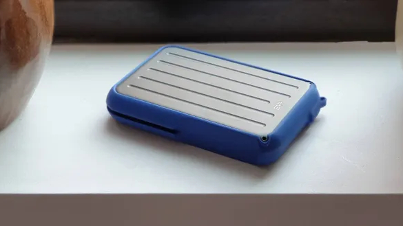 A rugged external drive sitting securely on a wooden shelf in an indoor setting.
