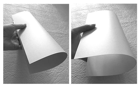 A diagram showing how paper fibers break when folded against the grain versus staying smooth when folded with the grain.