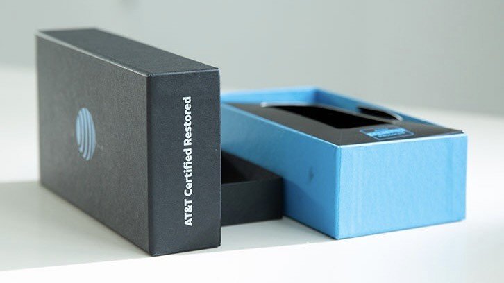 A white delivery box with AT&T branding containing a secured replacement smartphone.