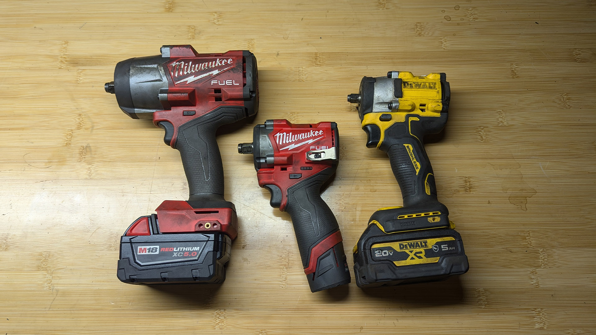 Side-by-side comparison of the Milwaukee M12 Stubby and the DeWALT Atomic impact wrench.