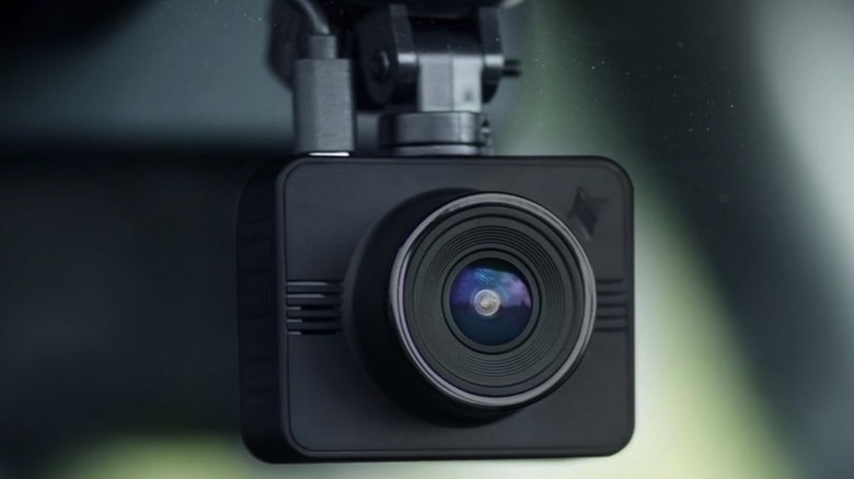 A Nexar Beam dash cam installed in a vehicle, showing its very small cylindrical form factor.