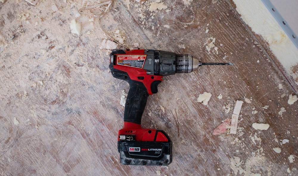 A person carefully wiping the yellow plastic housing of a power drill with a soft cloth.