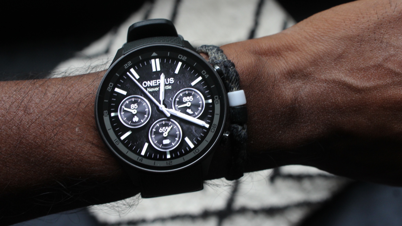 Close-up of a OnePlus Watch 2R on a wrist, showcasing a modern circular design.