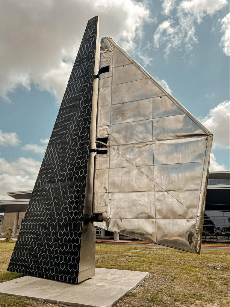 A large stainless steel Starship aerodynamic flap displayed as a public monument at an airport.