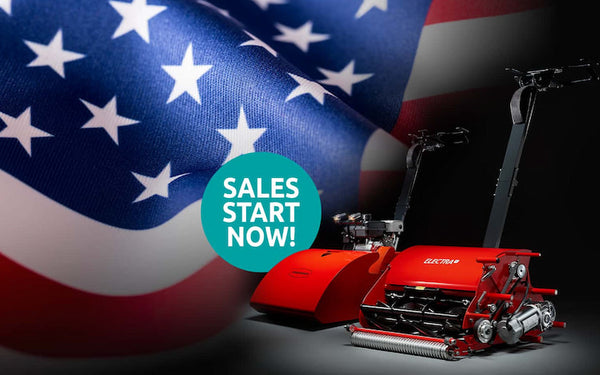 A promotional sign for Fourth of July lawn mower sales.