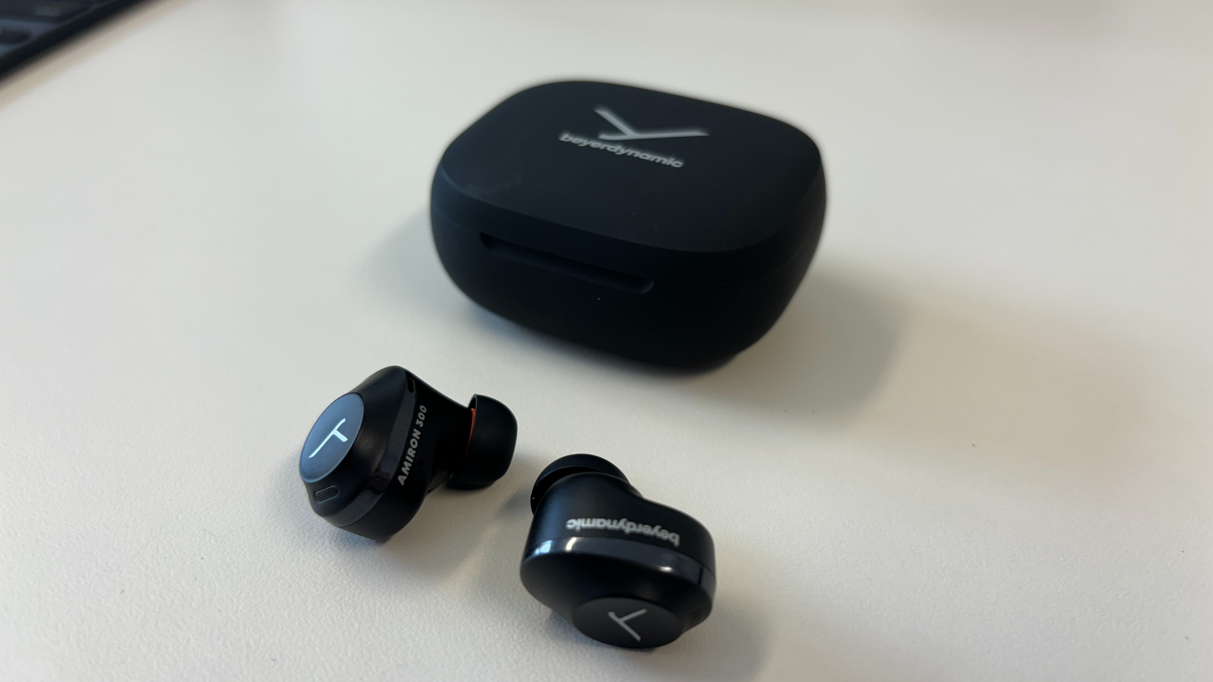 Beyerdynamic Amiron 300 wireless earbuds in a black charging case.