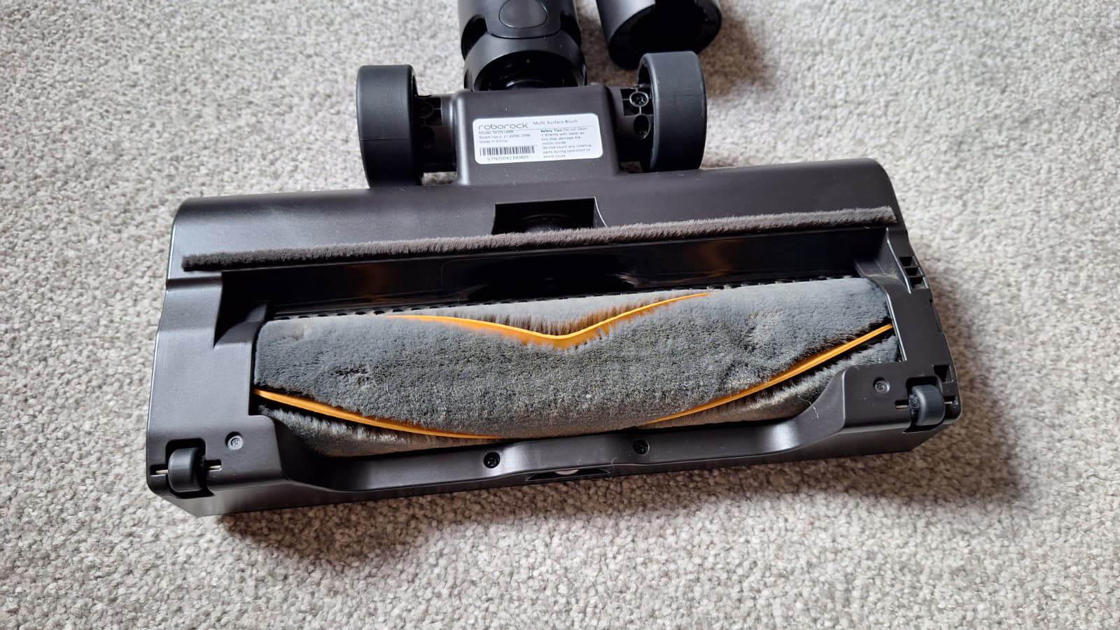 Bottom view of the Roborock H60 Hub Ultra floorhead showing the brushroll with rubber fins.