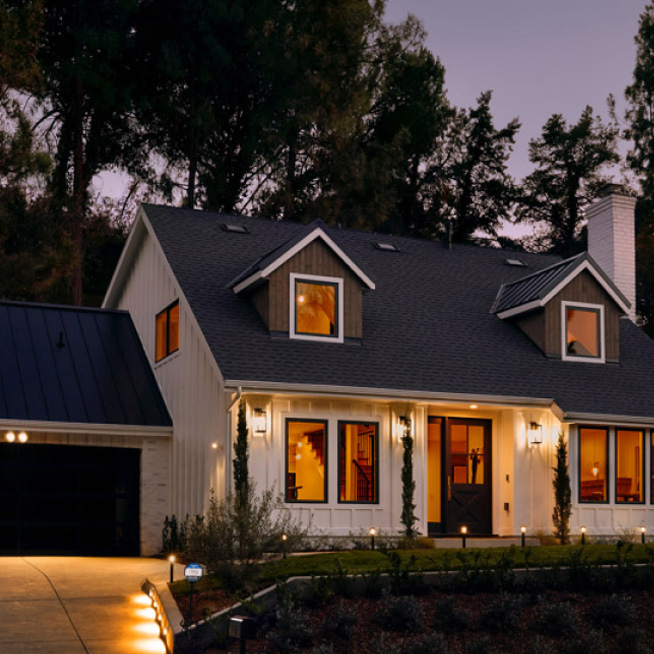 A modern house at dusk with illuminated pathway lights and landscape lighting.