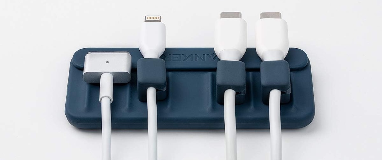 Anker magnetic cable holder with blue ties keeping charging cables organized on a desk edge.