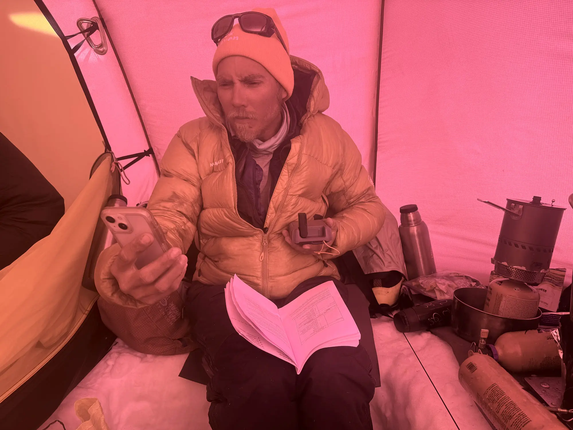 A close-up of a guide using a satellite device to send a text message.