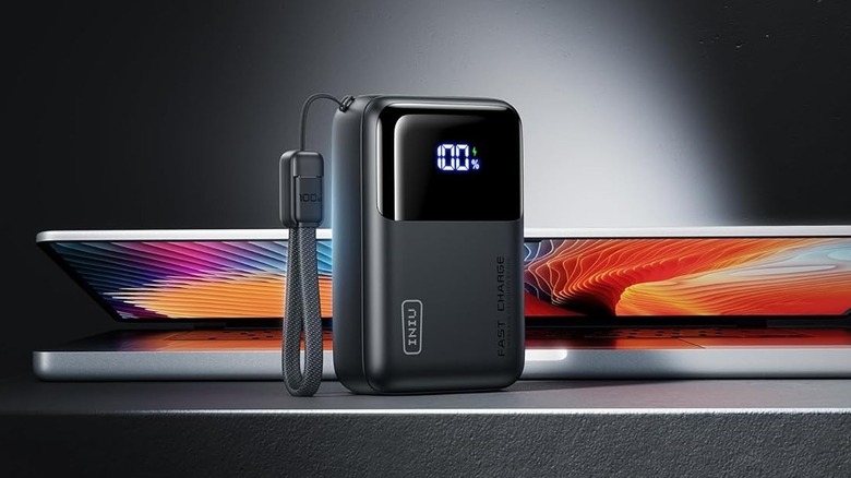 Slim INIU Cougar P62-E1 power bank positioned in front of a laptop.