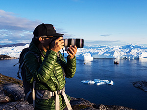 Photographer using a camera in a frozen, icy outdoor environment.