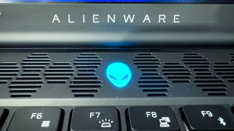 Macro view of an Alienware gaming laptop's cooling vents and glowing logo.
