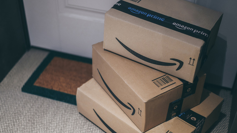 A stack of Amazon cardboard boxes sitting outside a front door.