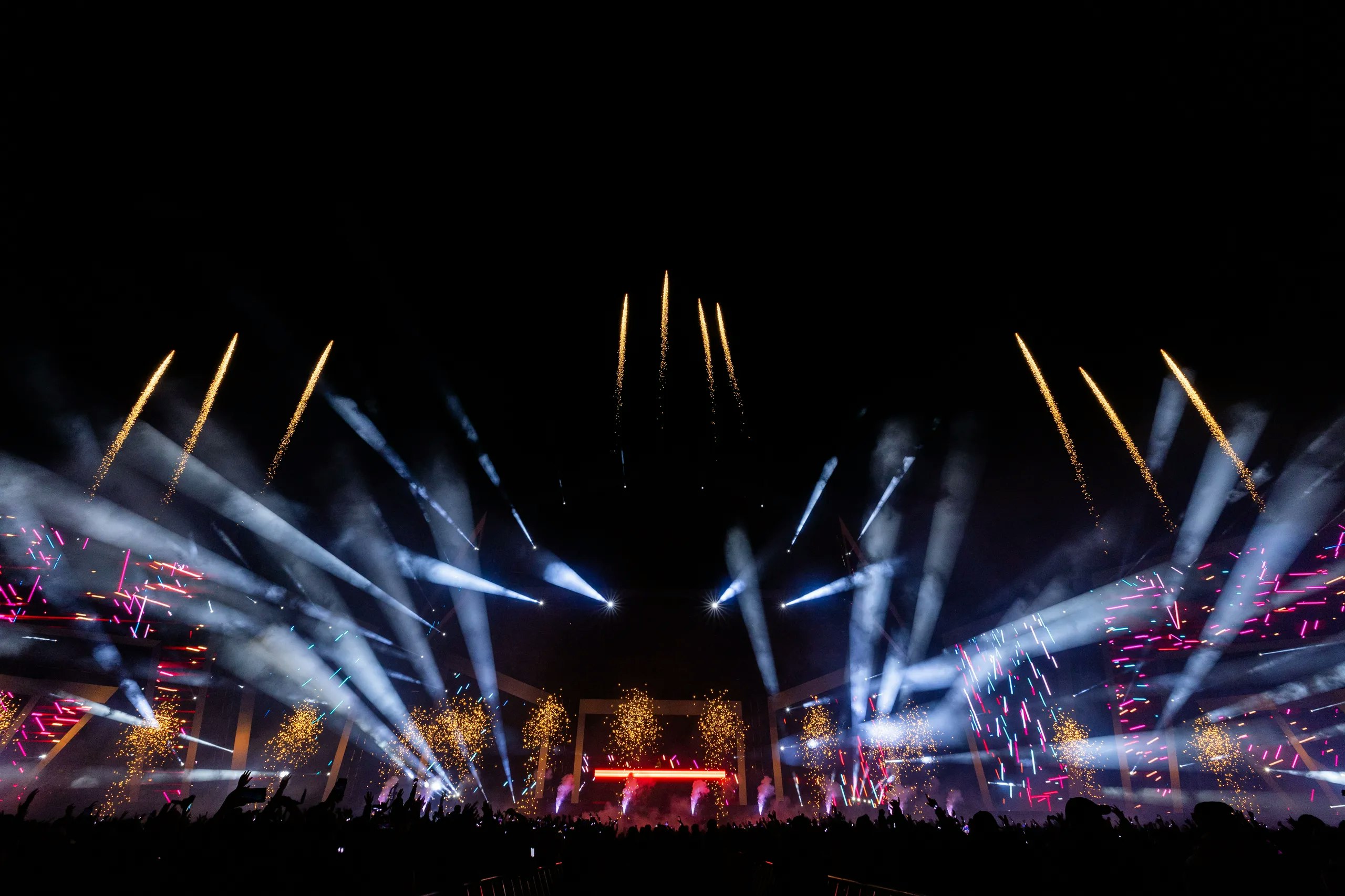 A digital avatar performing on a live stage with vibrant lighting effects.
