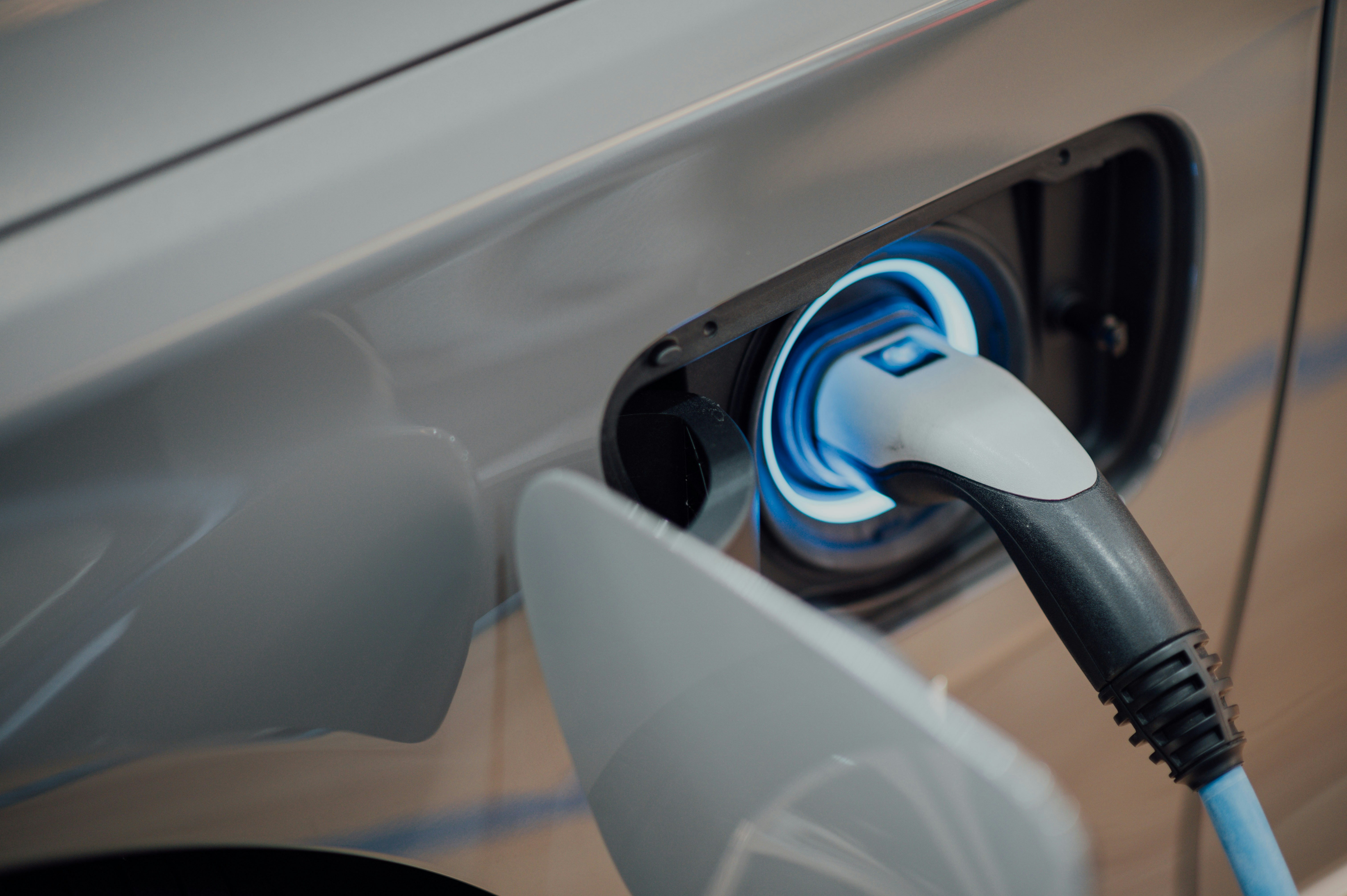 Close-up of an electric vehicle charging cable plugged into a high-voltage charging station.
