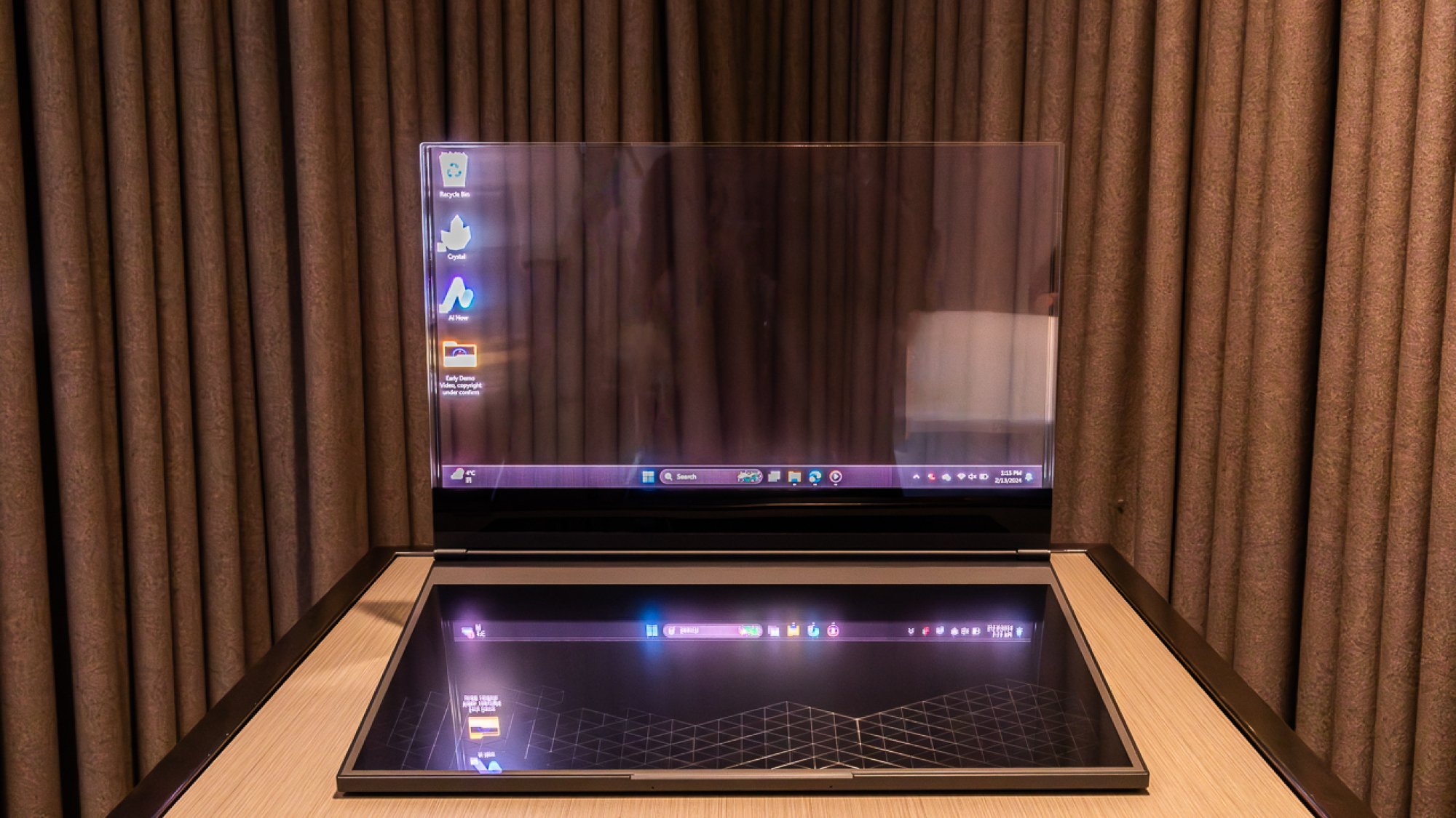 Windows 11 desktop interface visible on a transparent glass-like laptop screen.
