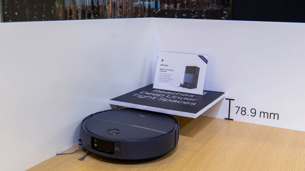 Side view of the 3i Q10 Ultra robot vacuum sliding underneath a low-profile wooden cabinet.