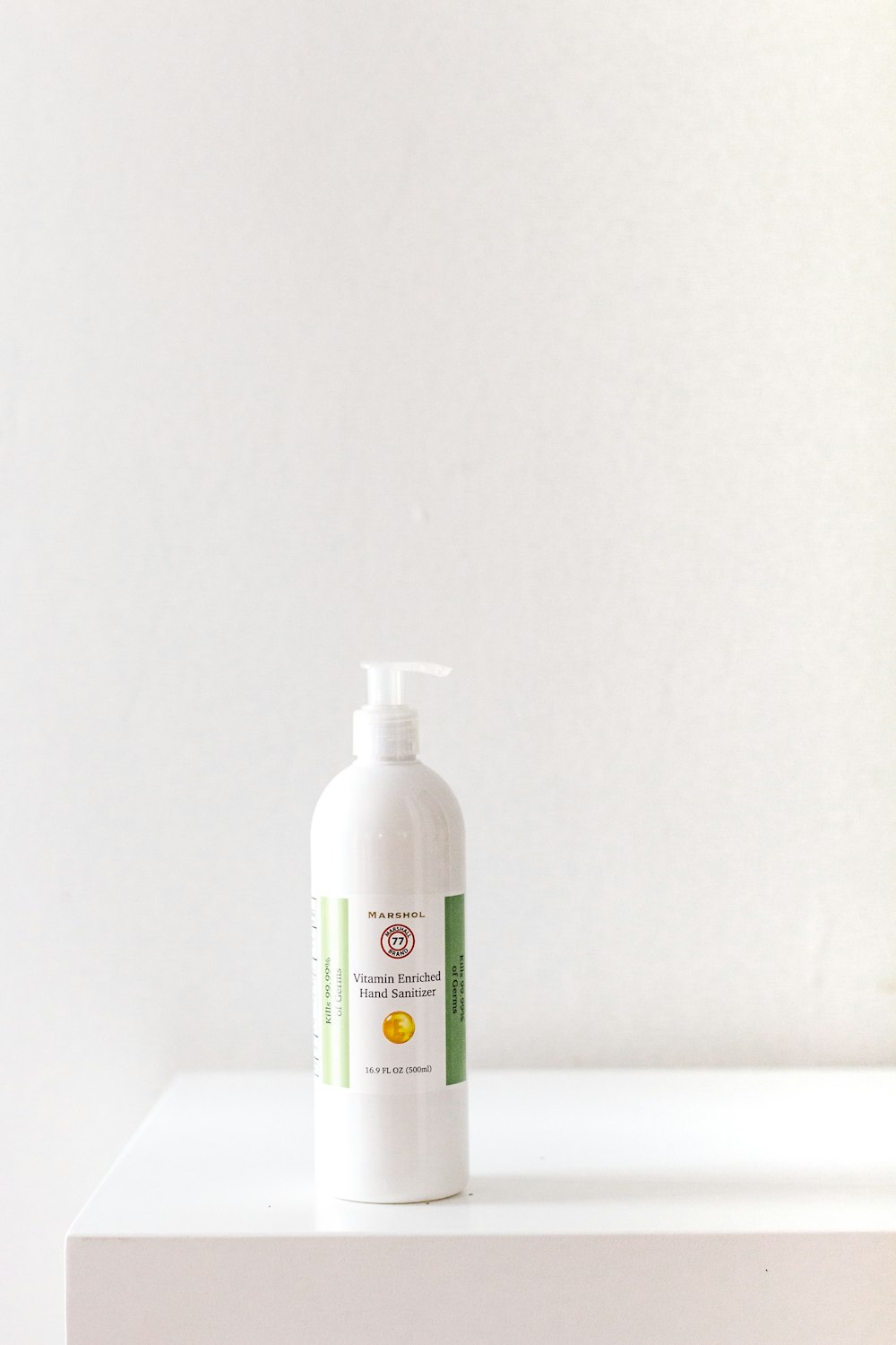 An Apple HomePod mini sitting on a wooden desk.