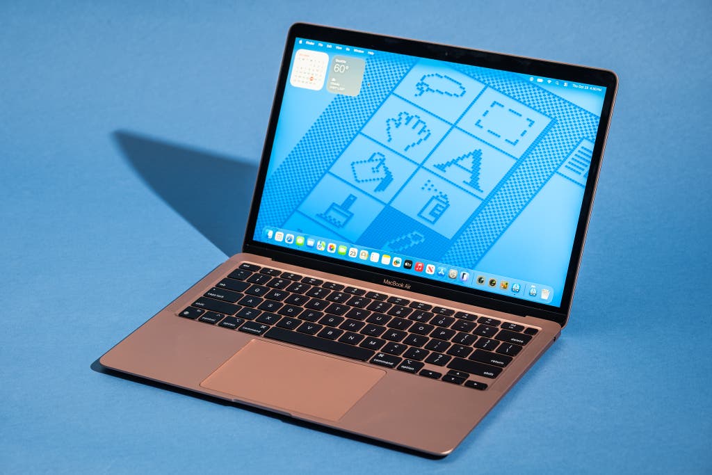 The classic Gold MacBook Air M1 on a blue desk surface.