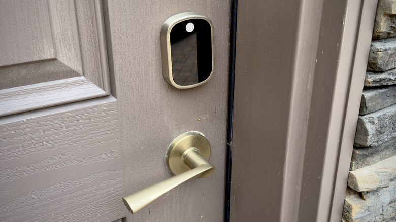A woman carrying multiple grocery bags and a baby, struggling to reach for keys.