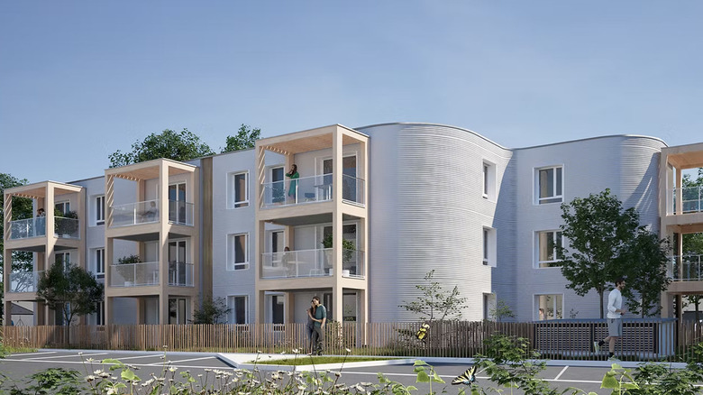 A completed multi-story apartment building with 3D-printed concrete walls and wooden accents.