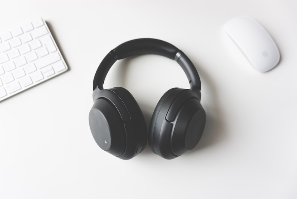 Modern noise-cancelling headphones resting on a wooden table.